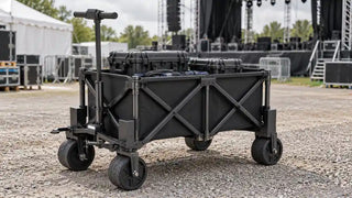 Electric work cart loaded with equipment beside a festival stage.
